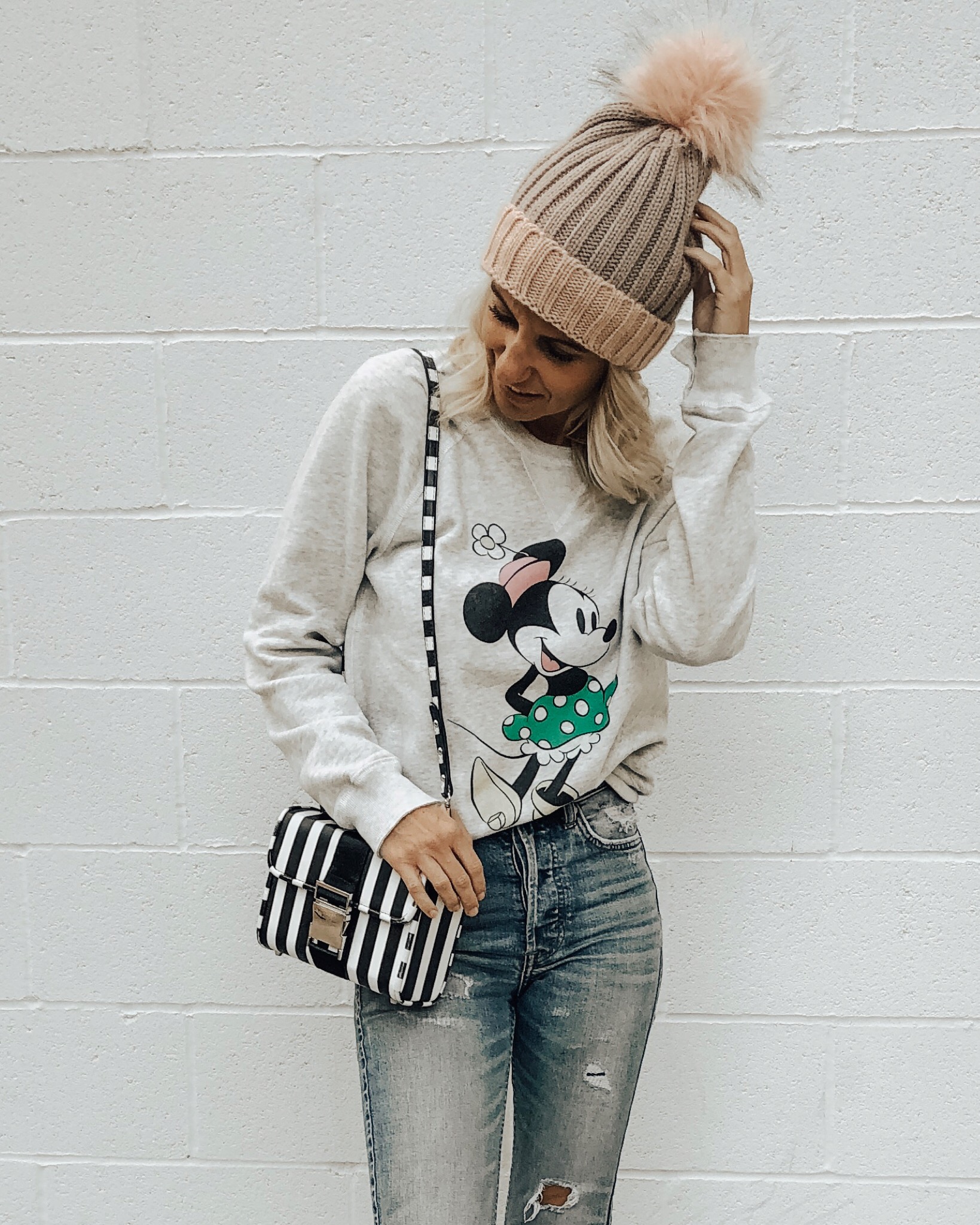 DECEMBER TOP 10- Jaclyn De Leon Style + Minnie Mouse sweatshirt + Disney inspired outfit + casual and cozy top + winter style + mom style + disney addict + pom pom beanie + striped handbag + distressed denim